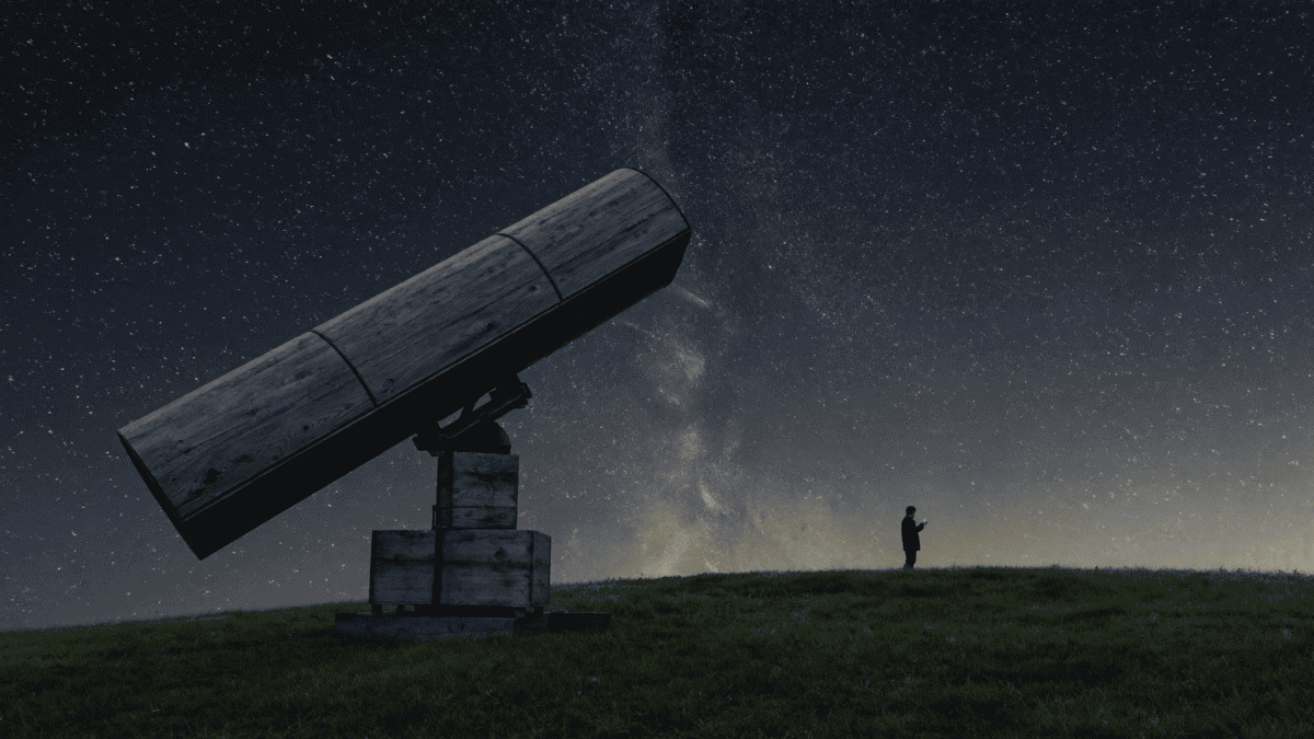 A large Dobsonian telescope silhouetted under a starry night sky with an astronomer beside it