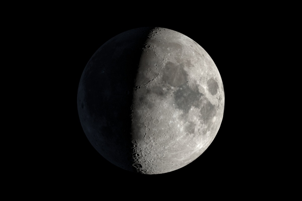 Waxing gibbous Moon photographed through a telescope, north up, with deep crater shadows along the terminator